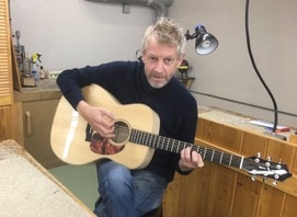 Andy Wakefield Hann, luthier at Fret & Nut, holding an acoustic guitar